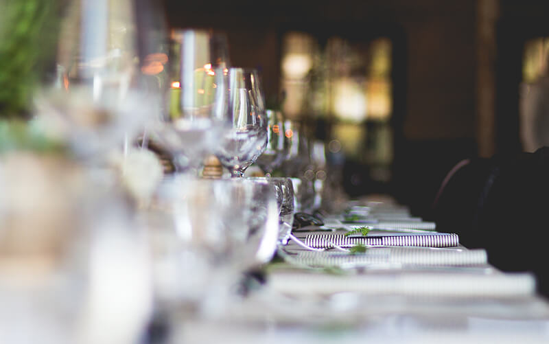 stock photo along dinner table with on place setting in focus