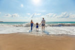 stock photo family (mum daughter dad) beach waves sky